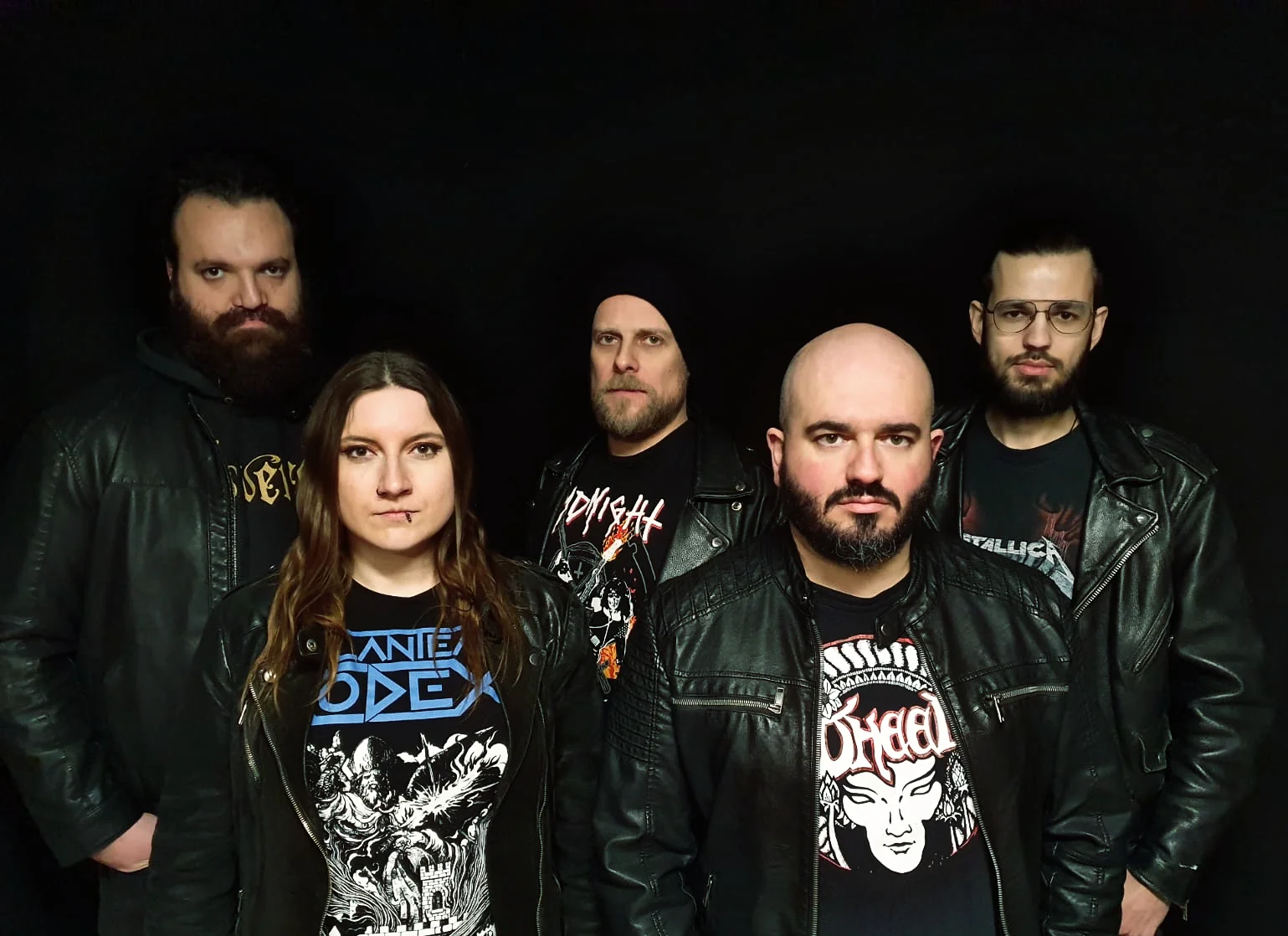 Band photo from Servants to the Tide.
There are three men in the back, a woman and a man in the front.
Everyone wears band shirts and black leather jackets.